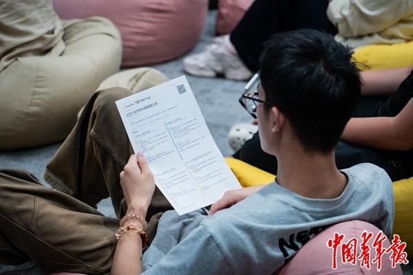 　　8月26日，北京亦庄模数OPC社区内，一名求职者半躺在沙发上查看招聘企业的“简历”。中青报·中青网记者 陈宇龙/摄