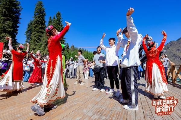 　　8月22日，天山天池，参加第二届“粤港澳青少年新疆行”文体交流活动的青少年学跳新疆舞。主办方供图