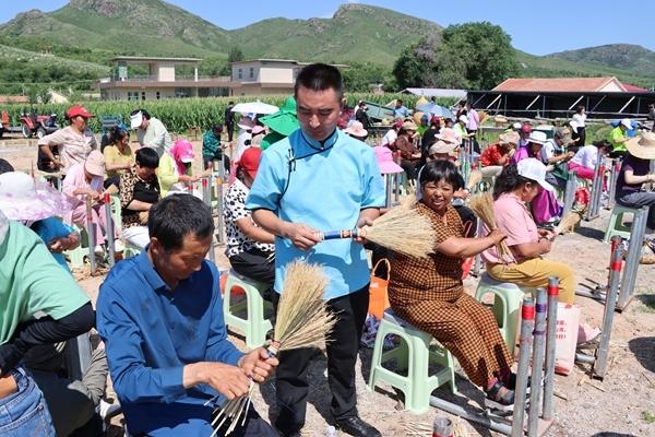　　李艳垒向前来学艺的村民传授笤帚苗手编技艺。受访者供图