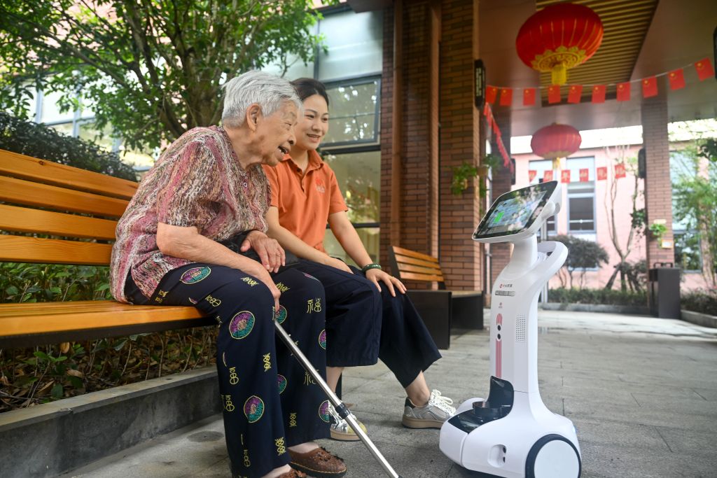 8月26日，在贵州省贵阳市乌当区一家康复中心，老年人和机器人互动。新华社发（袁福洪 摄）