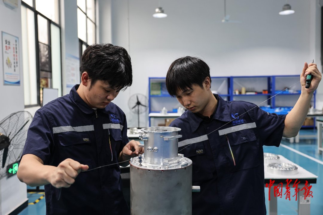 9月10日,江西赣州南康区,赣州低空经济产业园凌极推进(江西)科技有限公司,刘文琦(右)和袁润舟在为航空器发动机打锁丝加固。他们都出生于2005年,一年多前从江西应用技术职业学院机械电子工程专业毕业后,就来到这里工作。刘文琦说,自己毕业后就想从事航空领域的工作,来这里面试时,觉得有一定的专业门槛。目前他对这份工作很满意,朝九晚六、双休,工作强度不算大,还能学到东西,日后的待遇会越来越好。中青报·中青网记者 曲俊燕/摄