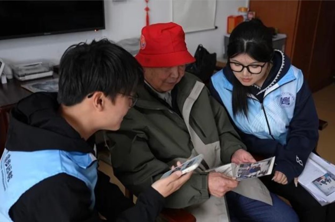 志愿者为老人送去上世纪70年代渔民出海合影的修复前后对比图。受访者供图