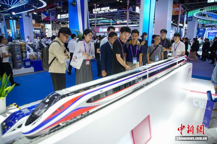 图为在东博会先进技术展区，参观者观看现场展出的中老铁路“澜沧号”动车组模型。陈冠言 摄