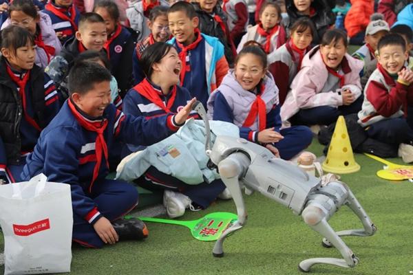 “它会摇头，还会跟我握手！”2025年11月，在平阴县龙山小学的操场上，一只仿生机器狗弯腰、摆尾，与孩子们亲密互动，引来阵阵惊呼与欢笑。齐鲁师范学院“校地共建∙筑梦乡村”科普进校园活动，把人工智能的种子悄悄播进乡村孩子的心田。齐鲁师范学院供图