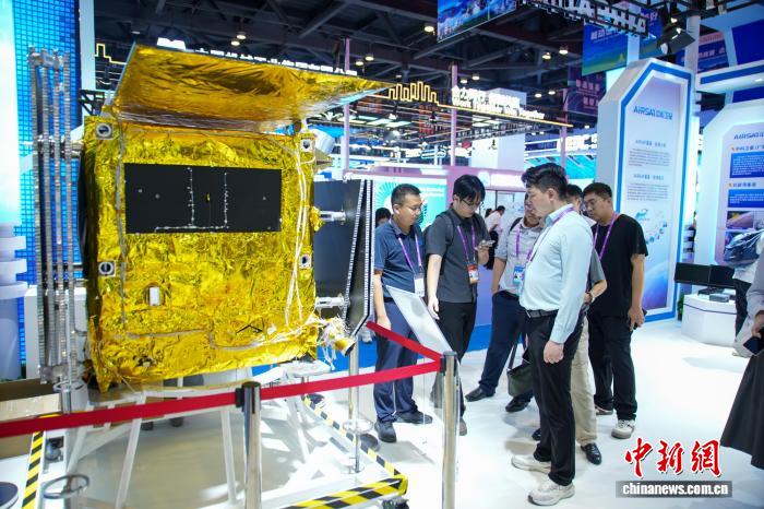 图为在东博会先进技术展区，参观者观看现场展出的AIRSAT-05星(地面验证星)模型。陈冠言 摄