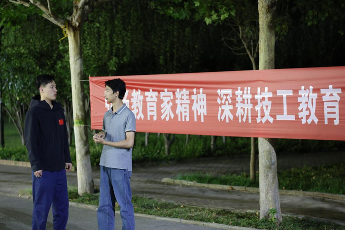 9月11日，刘宇轩（左）和他的技术教练在校园内交流。
