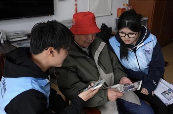 志愿者为老人送去20世纪70年代渔民出海合影的修复前后对比图。受访者供图