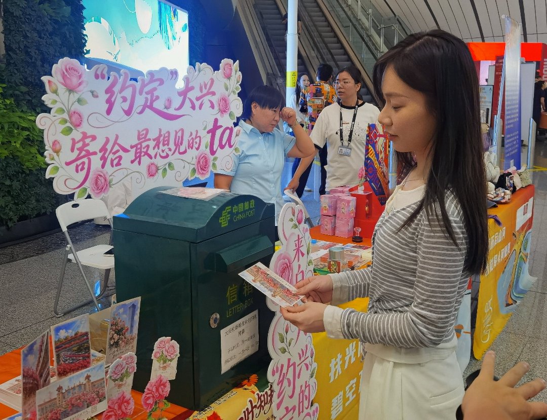 9月24日，北京大兴国际机场，航旅嘉年华现场，一名女孩将明信片投入邮箱。李庚伟/摄