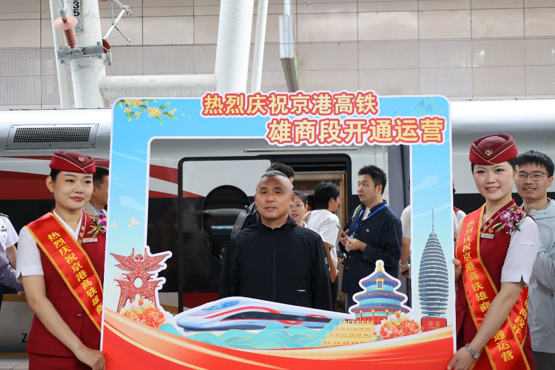 等待发车的旅客在站台与列车员合照。梁晓桐/摄