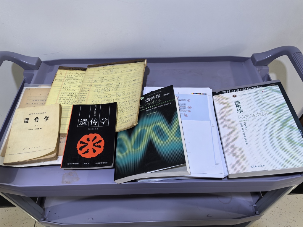 2026年9月下旬，吴燕华向记者展示四版《遗传学》教材。澎湃新闻记者 栾晓娜 摄