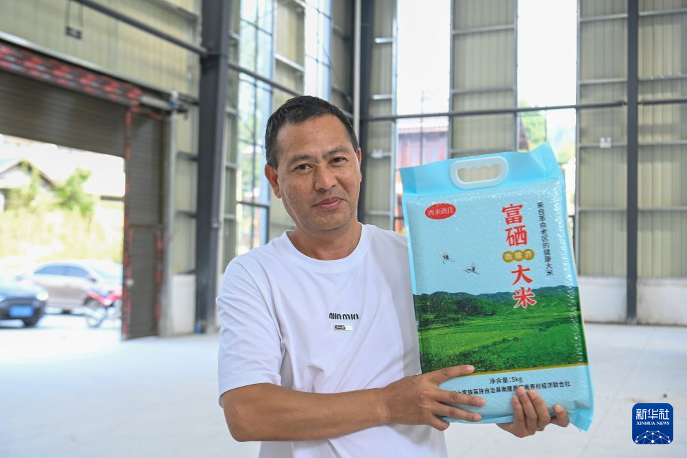 9月14日，在重庆市酉阳土家族苗族自治县南腰界镇南界村，村民展示新推出的富硒大米产品。新华社发（冉川 摄）