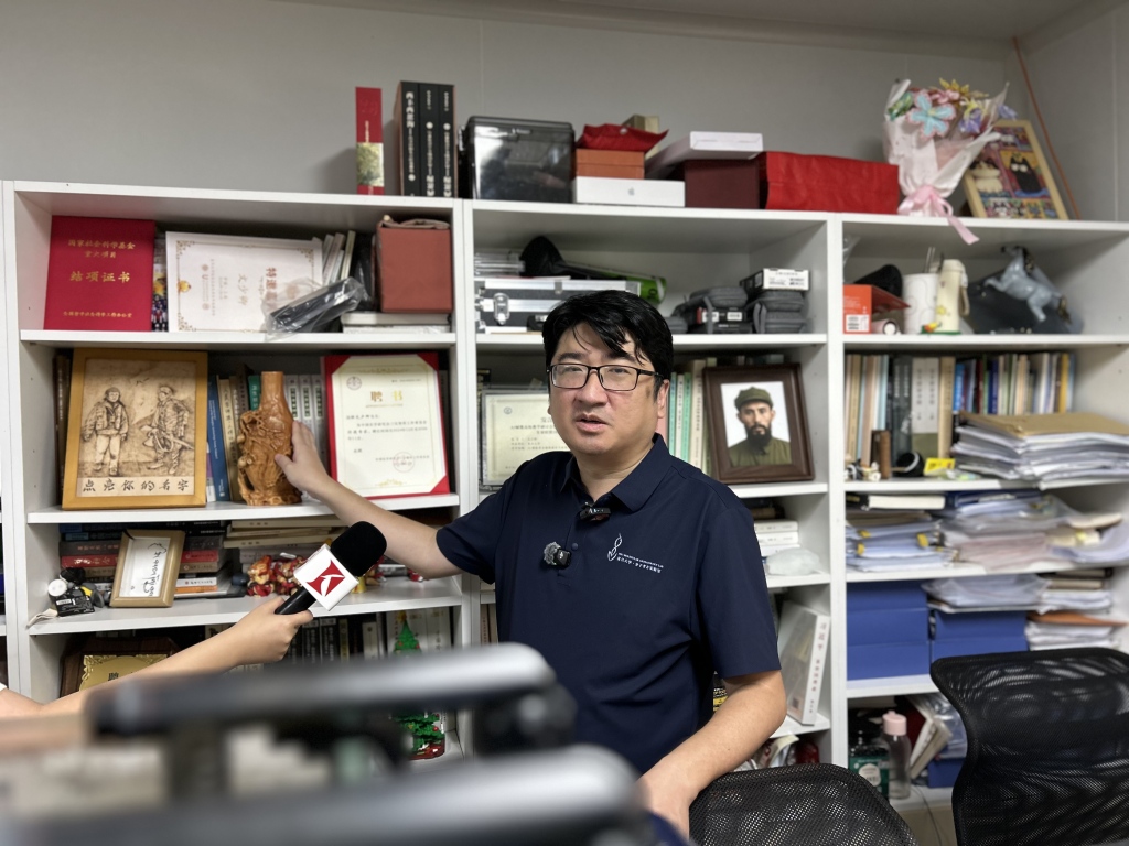 2026年9月，文少卿在复旦大学的办公室书柜前。澎湃新闻记者 李佳蔚 图