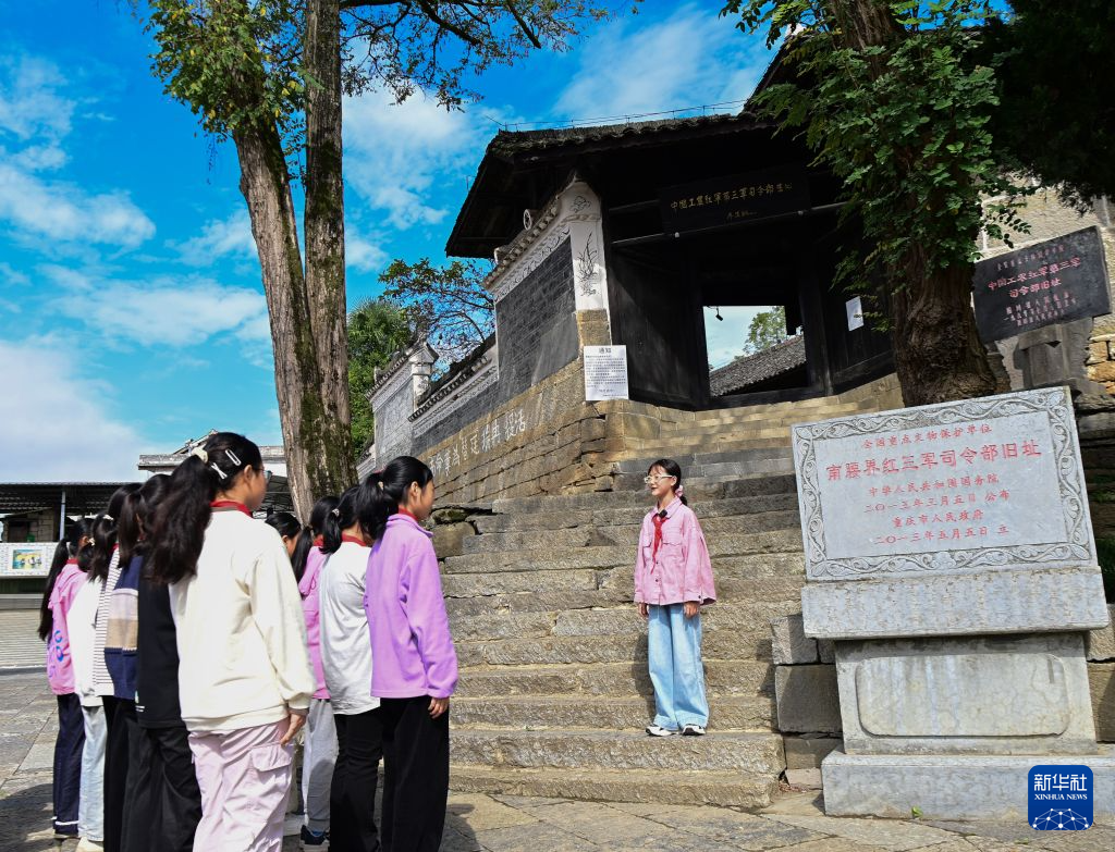 何冉静怡（右一）在重庆市酉阳土家族苗族自治县南腰界镇的中国工农红军第三军司令部旧址讲解红色故事（2025年10月17日摄）。新华社发（冉川 摄）