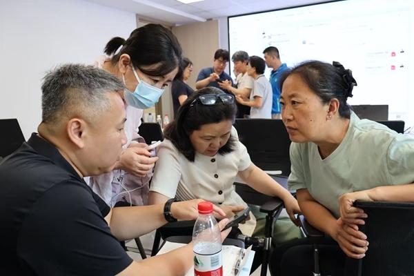 8月24日，北京市东城区和平里街道，AI培训课后，学员们向讲师请教问题。实习生 张皓宇/摄