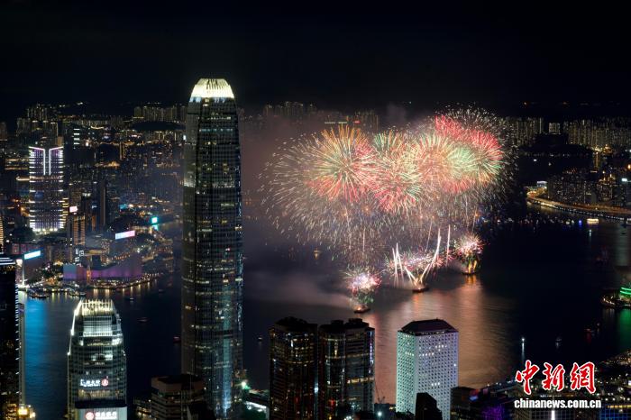 10月1日晚，香港举办2026年国庆烟花汇演，庆祝中华人民共和国成立77周年。图为璀璨烟花与维港两岸夜景交织辉映。中新社记者 李志华 摄