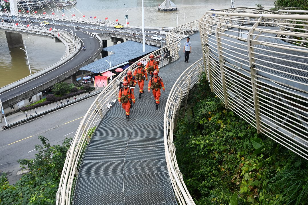 10月2日，福建南平，消防员沿着景区栈道开展山林沿线徒步巡护，沿途排查步道周边山林防火隐患，筑牢城区山林外围防线。杨鸿磊/摄