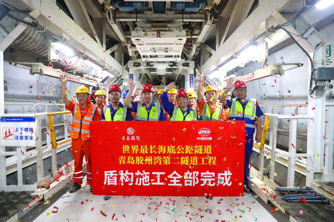 10月2日,山东青岛,胶州湾第二隧道盾构施工现场,工人们合影庆祝盾构施工全部完成。胶州湾第二海底隧道工程全长17.48公里,按“双主线隧道+中间服务隧道”布局,双向六车道,设计时速80公里,是全球建设规模最大、长度最长的海底公路隧道。张进刚/摄