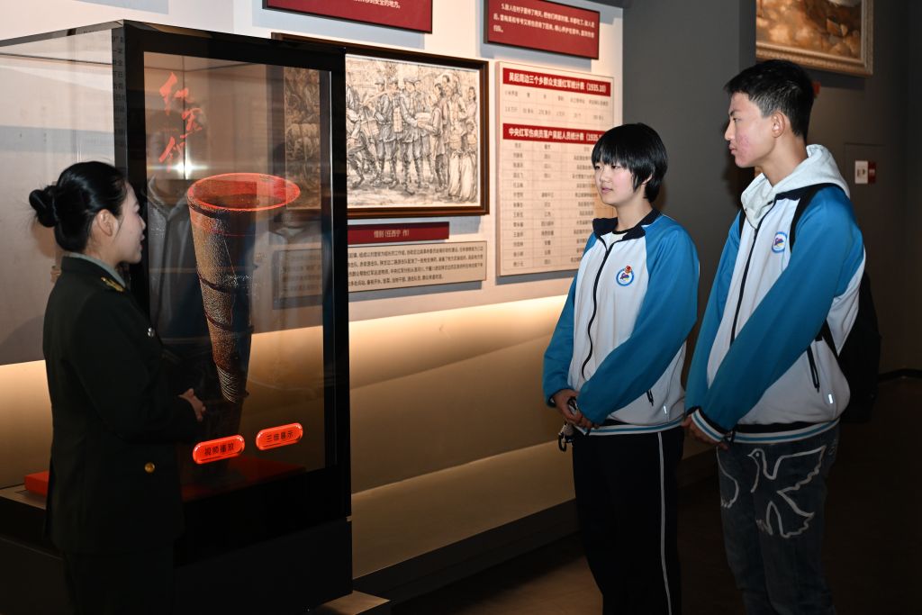 10月1日，延安市新区高级中学学生王茜湲（右二）、齐思成（右一）在陕西吴起县中央红军长征胜利纪念馆聆听讲解。新华社记者 邹竞一 摄