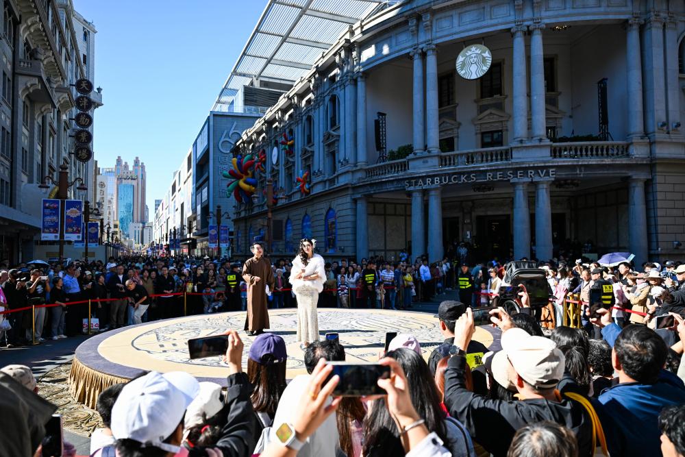 10月6日，游客在天津金街观看话剧《日出》片段表演。