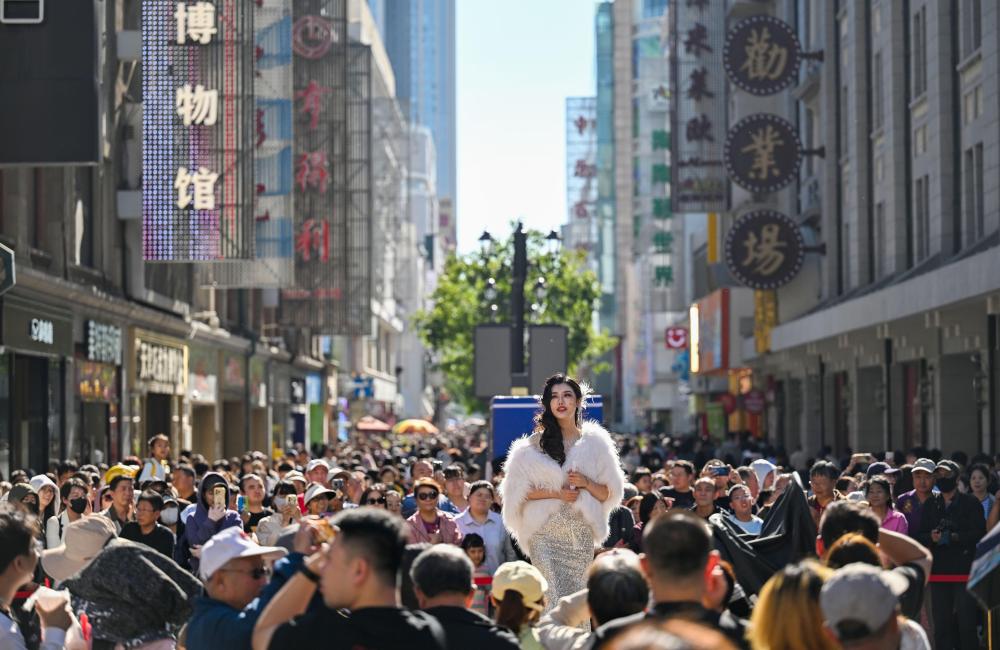 10月6日，游客在天津金街观看话剧《日出》片段表演。