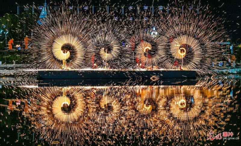 2026年9月25日，山西省运城盐湖景区，民间艺人表演非遗打铁花。璀璨星火与月色相映，吸引众多市民游客驻足观赏，共度中秋佳节。(薛俊摄/光明图片)
