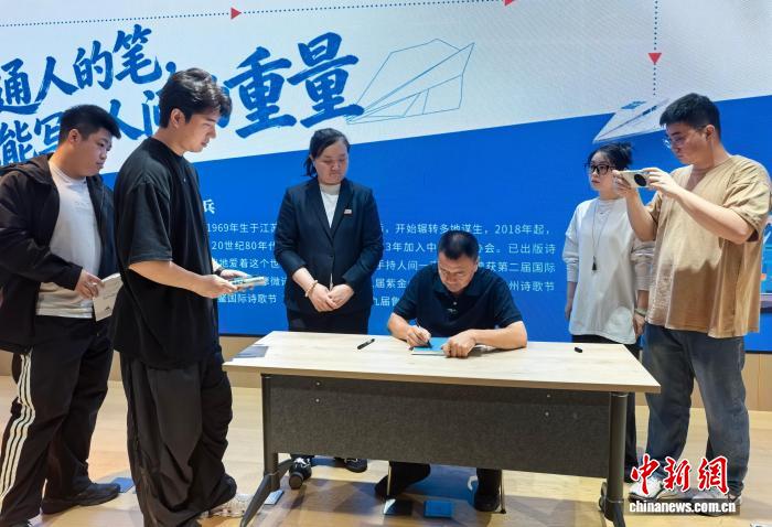 王计兵为读者签名。中新网记者 常慕城 摄