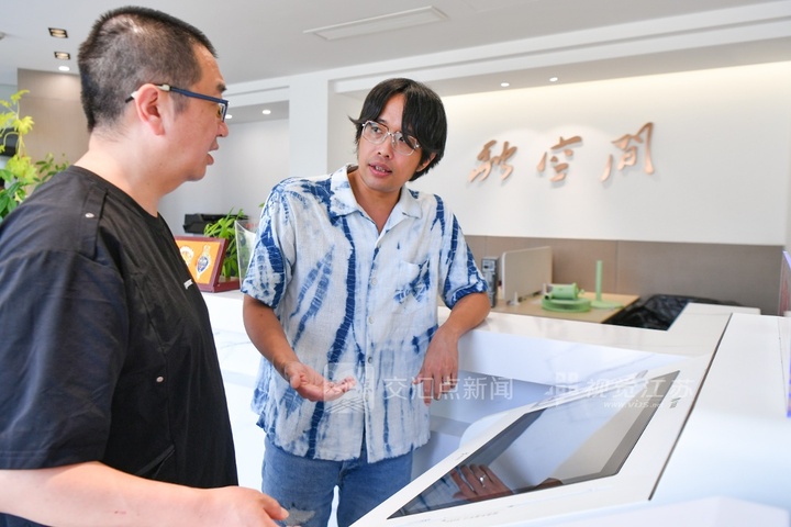 台湾青年蓝刚毅（右）在上海首个台胞一站式服务窗口办理事务。