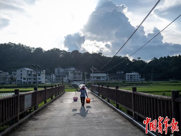 7月29日，贵州省黎平县少寨村，村民从新红军桥走过。中青报·中青网记者 李隽辉/摄