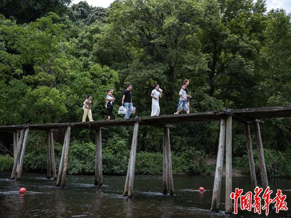 8月2日，贵州黎平少寨村，从县城来的游客们走过红军桥，准备下河纳凉。这个有着优美自然风光的村落，在炎热的夏季吸引着城里人来此避暑消夏。中青报·中青网记者 李隽辉/摄