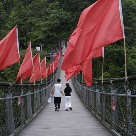 2026年5月13日，贵州省遵义市娄山关，来自桐梓县的小两口陈麒麟（左）和王怡走在长空桥上。“雄关漫道真如铁，而今迈步从头越。”1935年2月，红军取得娄山关大捷后，毛泽东创作了这阕《忆秦娥·娄山关》。