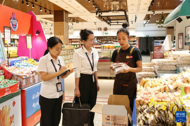 10月18日，云南省蒙自市纪检监察干部在一超市开展民生领域监督检查，向商户了解商品进货查验、保供稳价相关情况。 新华社发（薛莹莹摄）