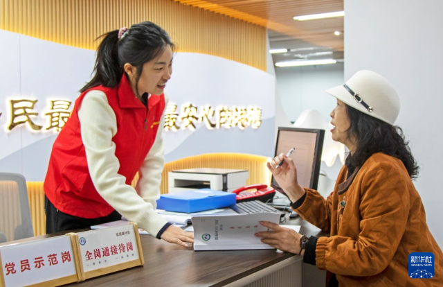 4月22日，在湖北省恩施市小渡船街道办事处机场路社区，“全岗通”政务服务工作人员指导居民办理业务。恩施市在城市社区便民服务大厅设置“全岗通”专岗，实现“一岗通办、一体多用、一专多能”，提升为民服务办事效率。 新华社发（谭华摄）